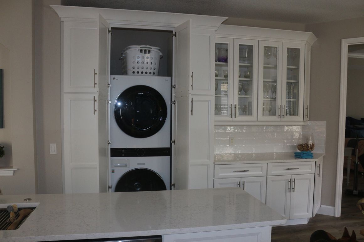 A washer and dryer are stacked on top of each other in a kitchen.