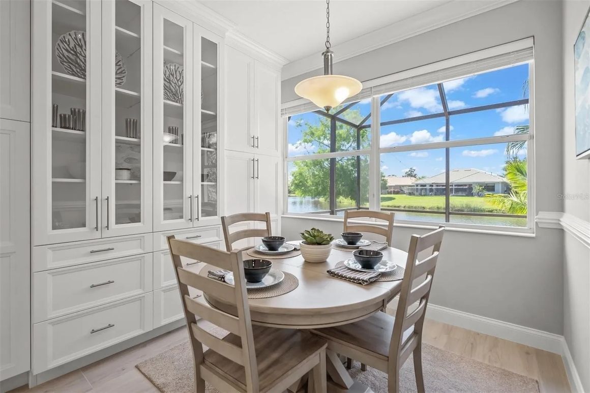 A dining room with a table and chairs and a window.