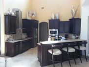A kitchen with black cabinets , stainless steel appliances , and a large island.