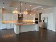 An empty kitchen with white cabinets and stainless steel appliances.