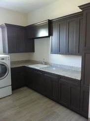 A laundry room with a washer and dryer , sink , and cabinets.