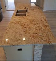 A kitchen with a granite counter top and a sink.