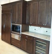 A kitchen with wooden cabinets , stainless steel appliances , and a wine cooler.