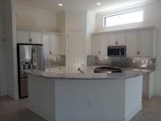A kitchen with white cabinets , stainless steel appliances , and a large island.