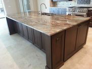 A kitchen with a large island and granite counter tops.