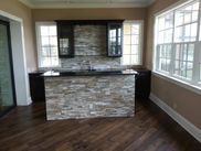 A kitchen with a large island and lots of windows.