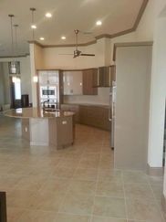 A kitchen with stainless steel appliances , granite counter tops , and a ceiling fan.