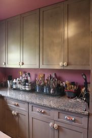 A kitchen with purple cabinets and a granite counter top.