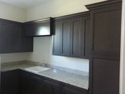 A kitchen with black cabinets and granite counter tops.
