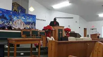 A man is standing at a podium in a church giving a sermon.