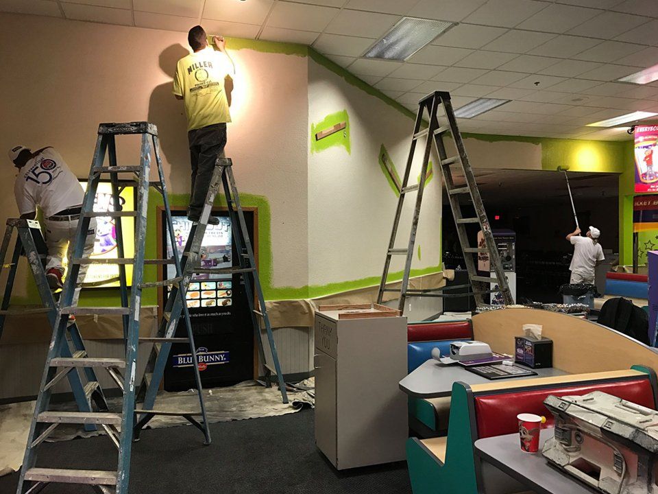 Workers Painting The Commercial Store Interior