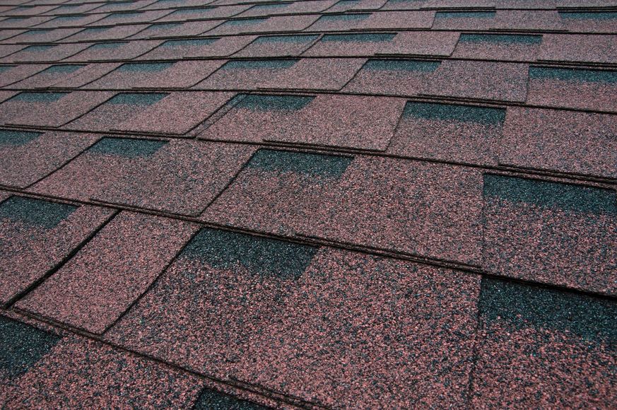 Close-up of a brown and black asphalt shingle roof.