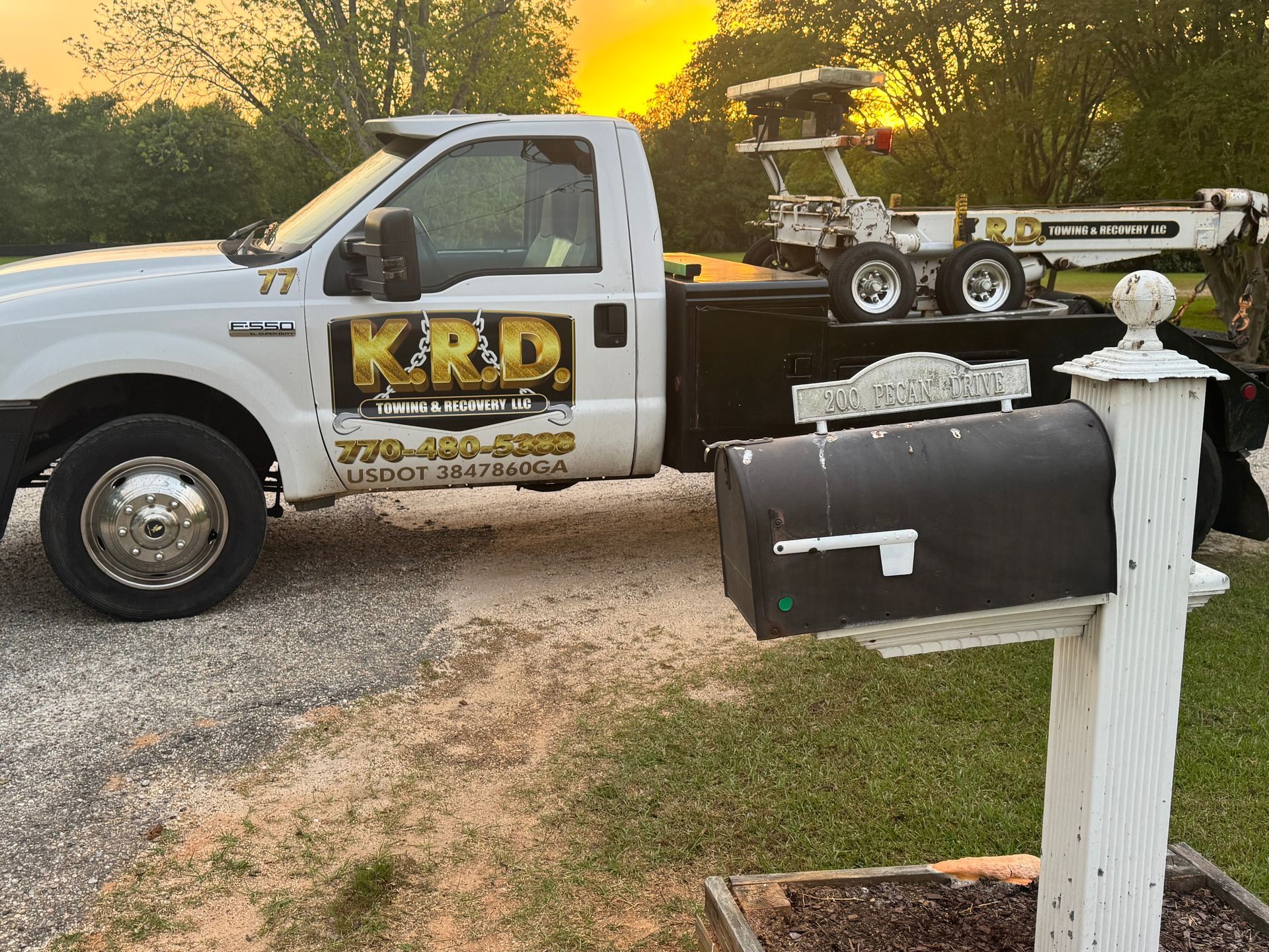 A tow truck is parked next to a mailbox.