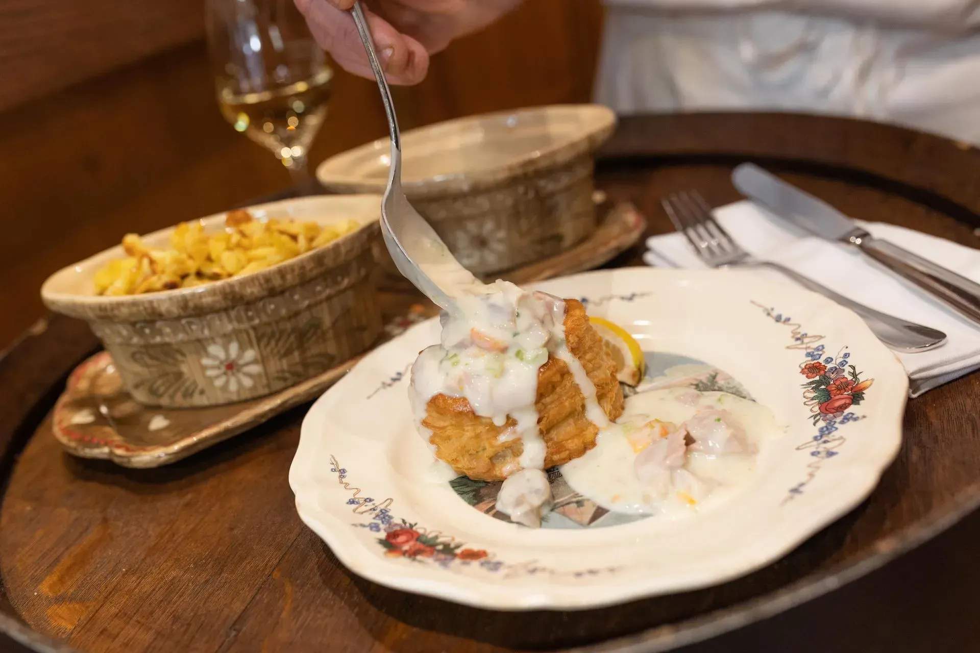 Une personne tient une fourchette au-dessus d'une assiette de nourriture.