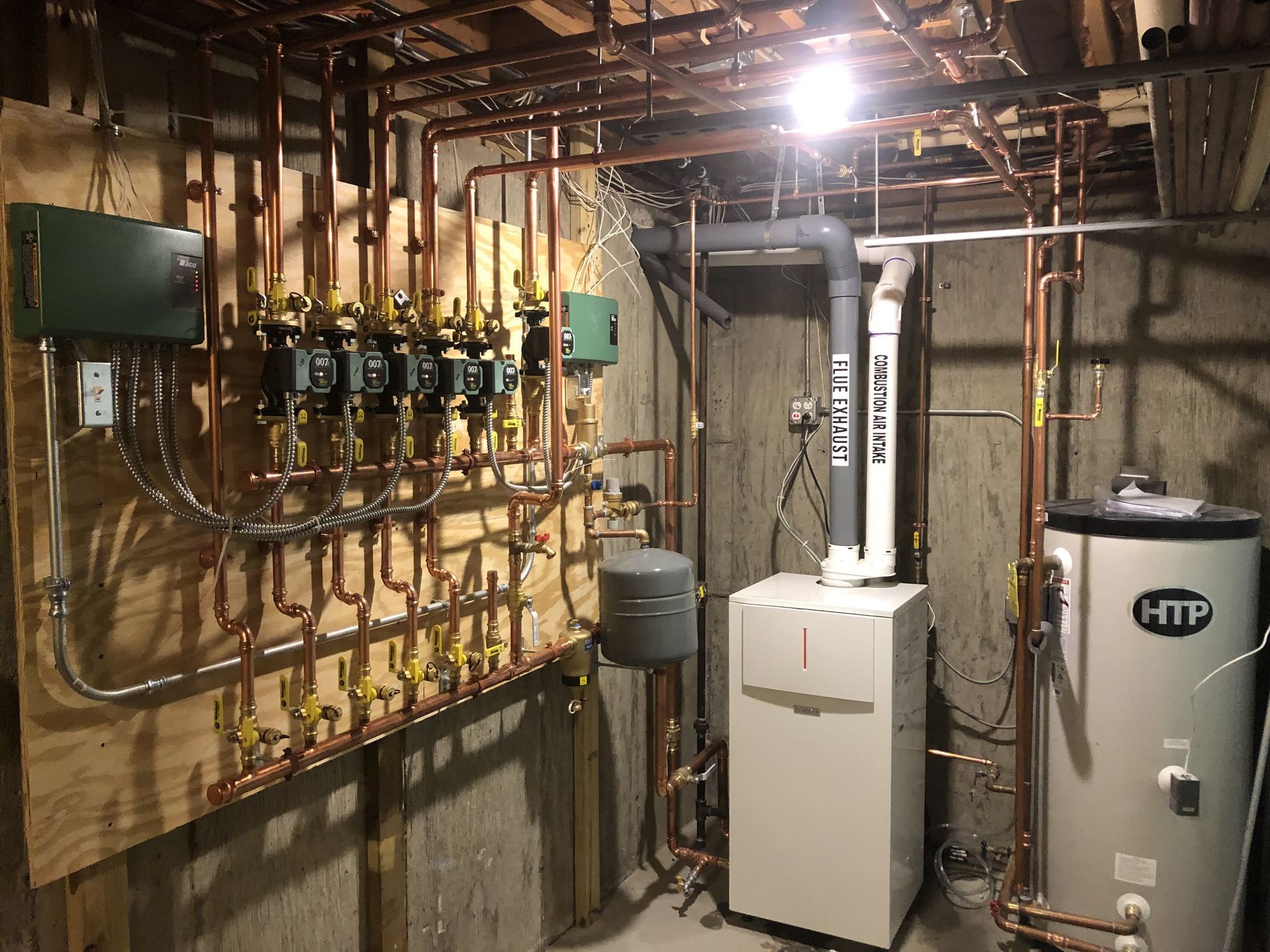 A basement with a lot of pipes and a water heater.