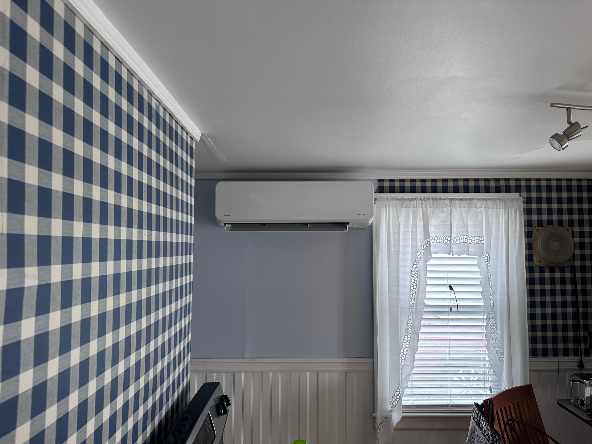 A room with a blue and white checkered wall and a window.