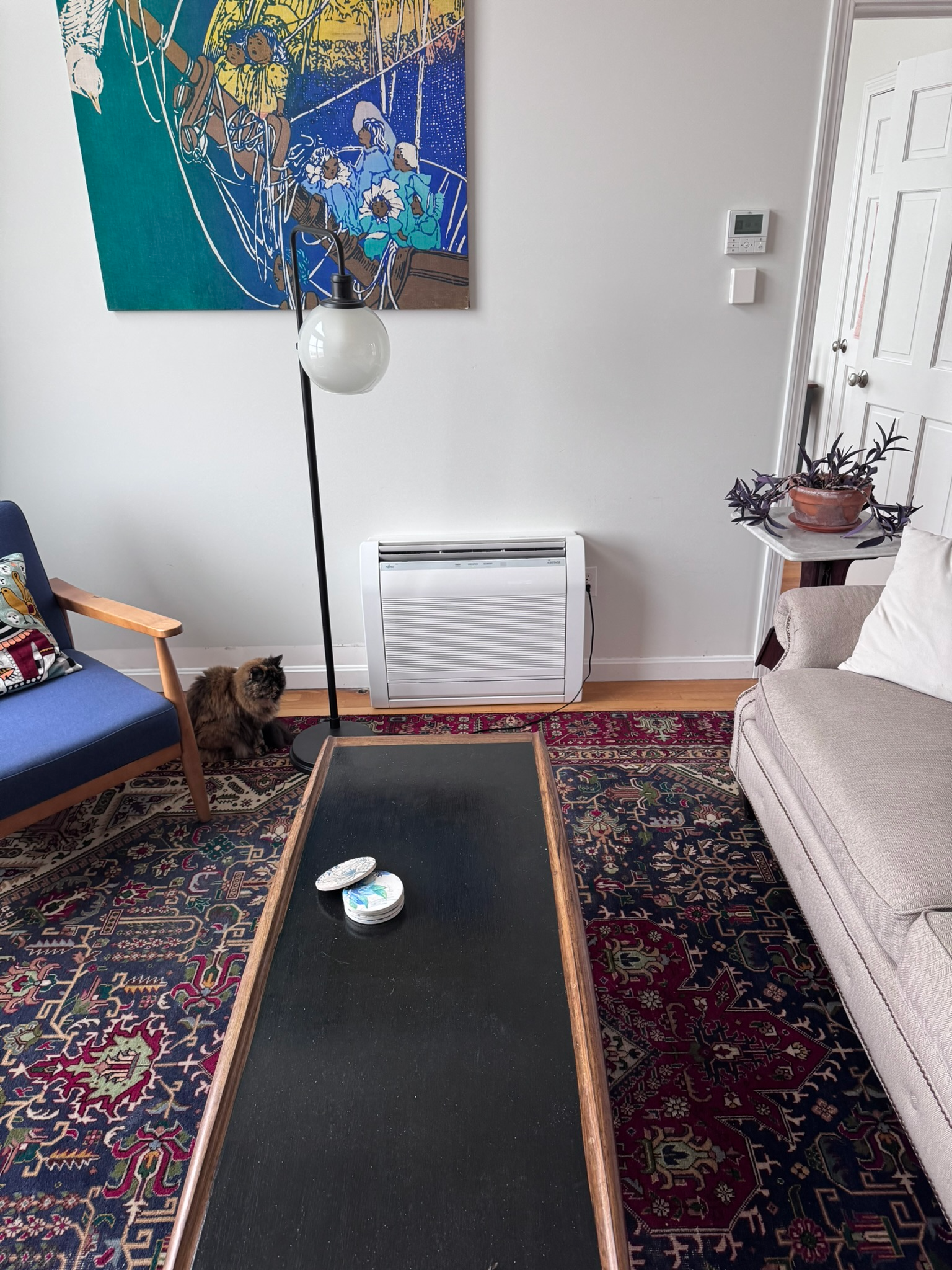 A living room with a couch , chair , coffee table and rug.