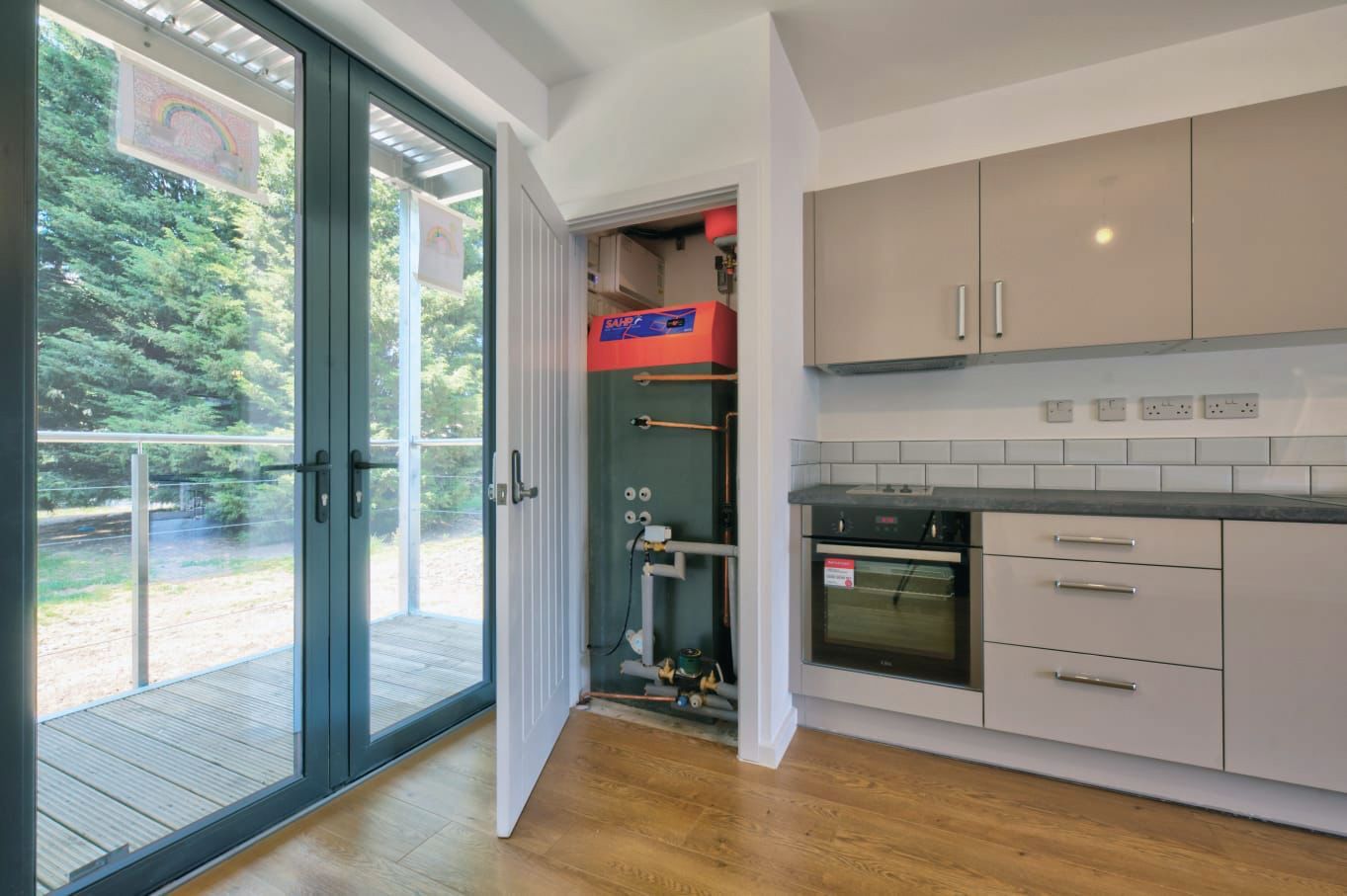 A kitchen with a sliding glass door leading to a balcony.