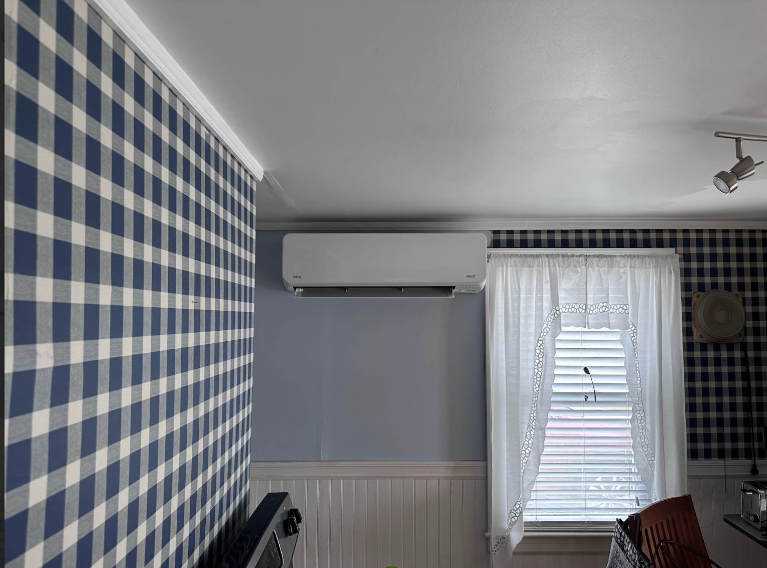 A room with a blue and white checkered wall and a window.