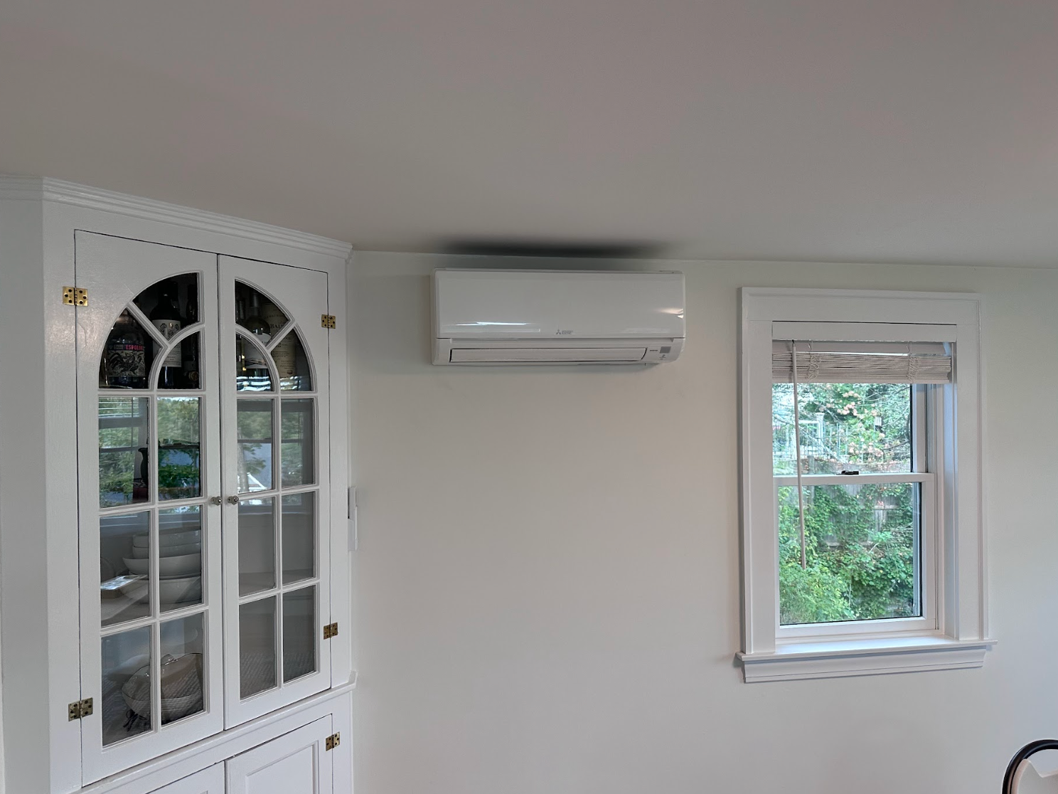 A room with two windows and a refrigerator on the wall.