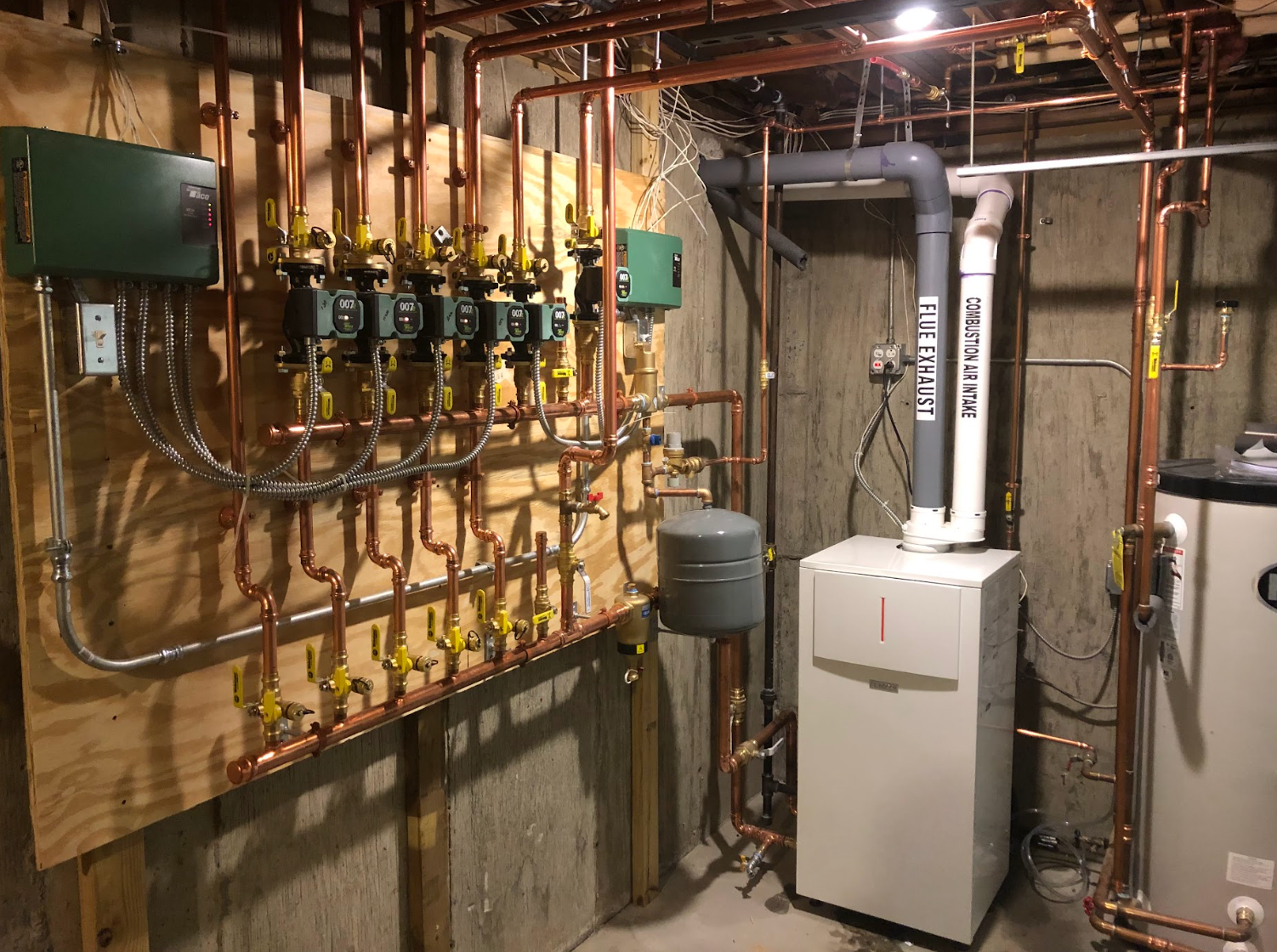 A room filled with lots of pipes and a boiler.