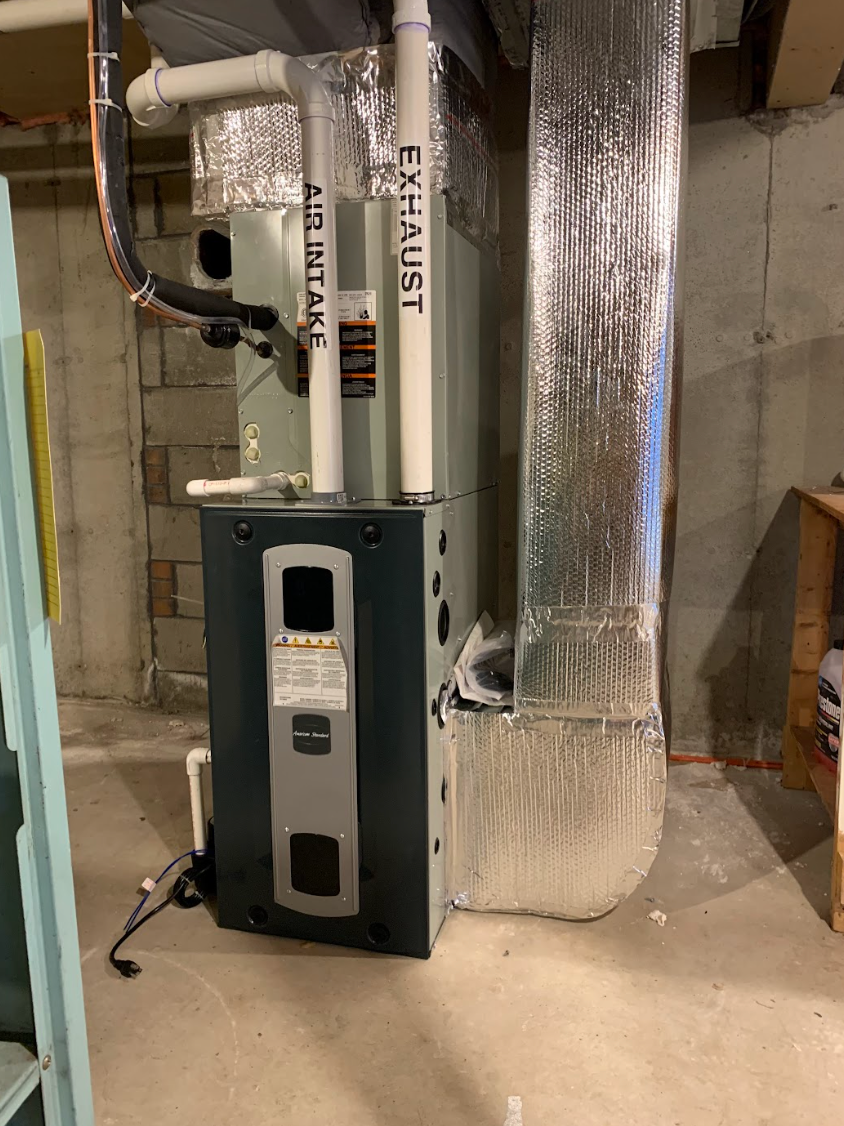 A room filled with lots of pipes and a boiler.