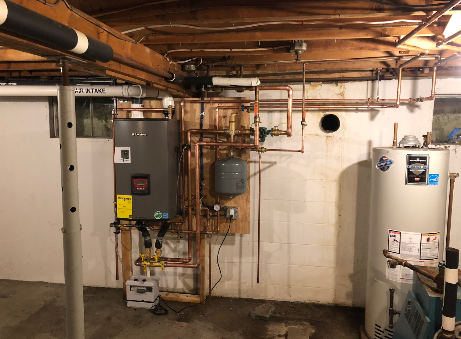 A basement with a water heater and a boiler.