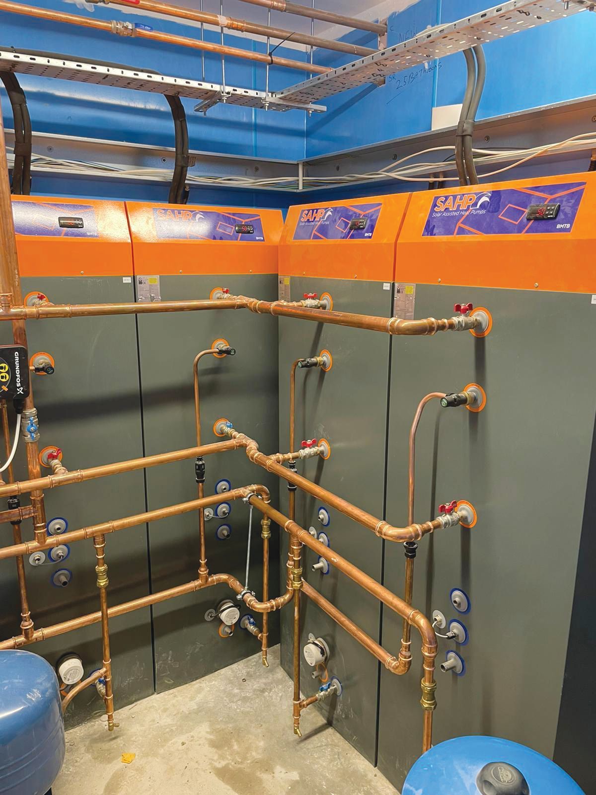 A room with a lot of pipes and controls on the wall