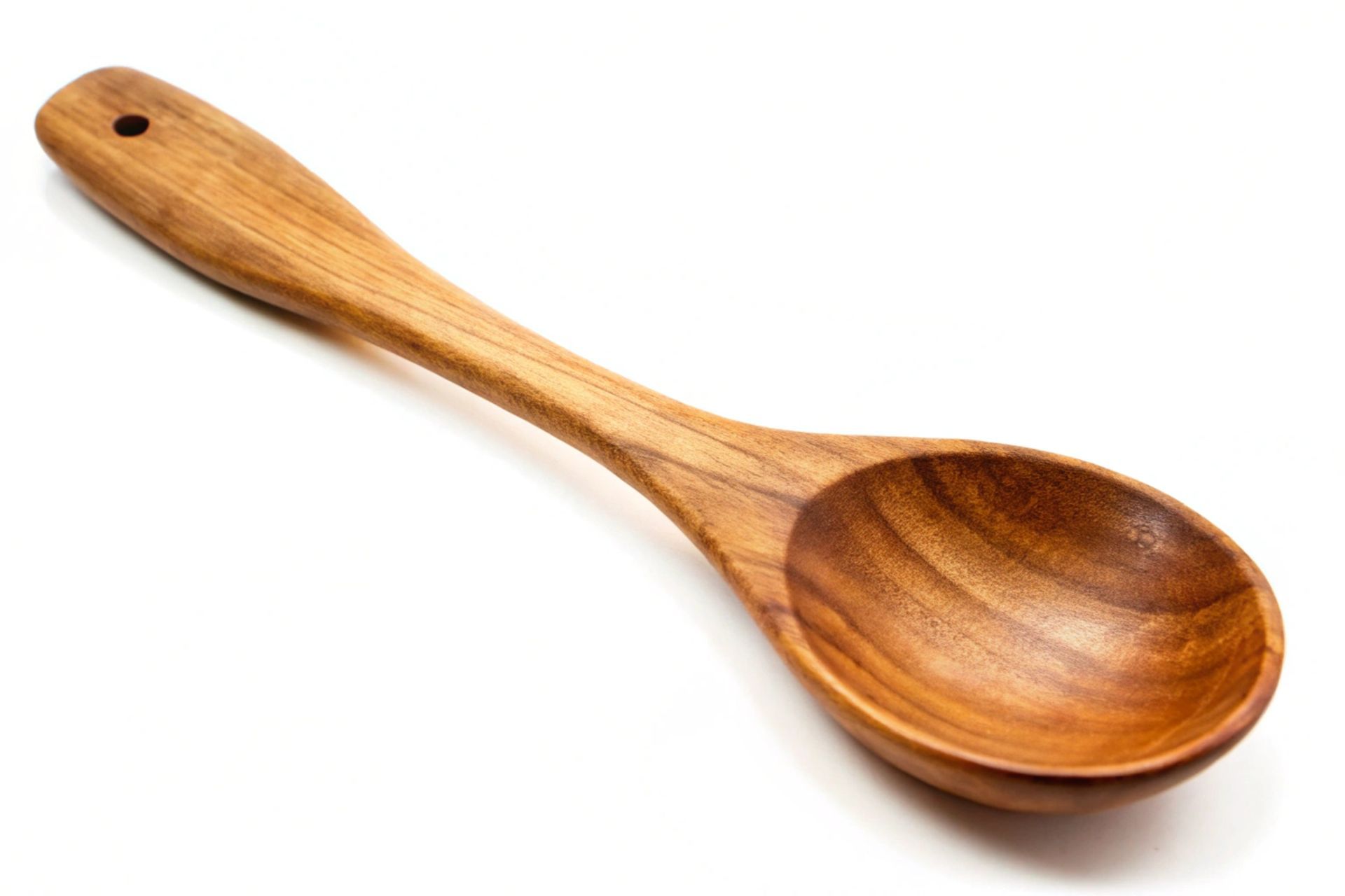 A wooden spoon with a hole in the handle on a white background