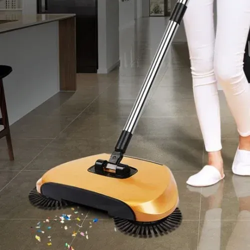A woman is using a broom to clean the floor in a kitchen.
