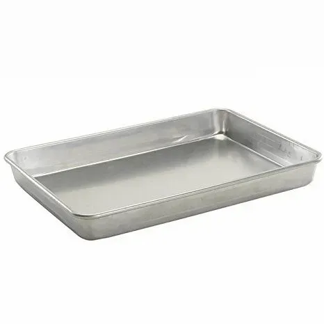 A stainless steel pan is sitting on a white surface.
