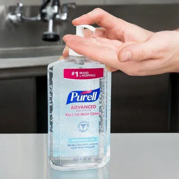 A person is using a bottle of purell hand sanitizer