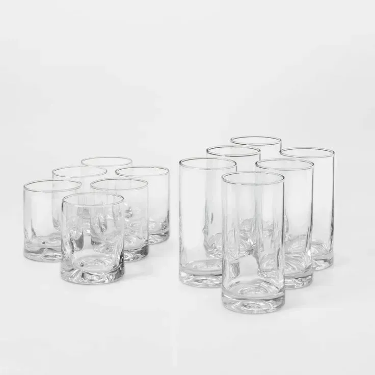 A set of twelve clear glasses on a white surface.