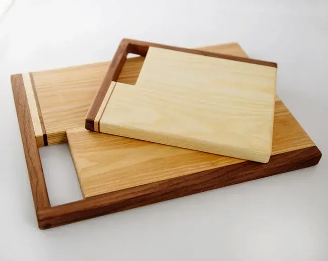 Two wooden cutting boards are stacked on top of each other