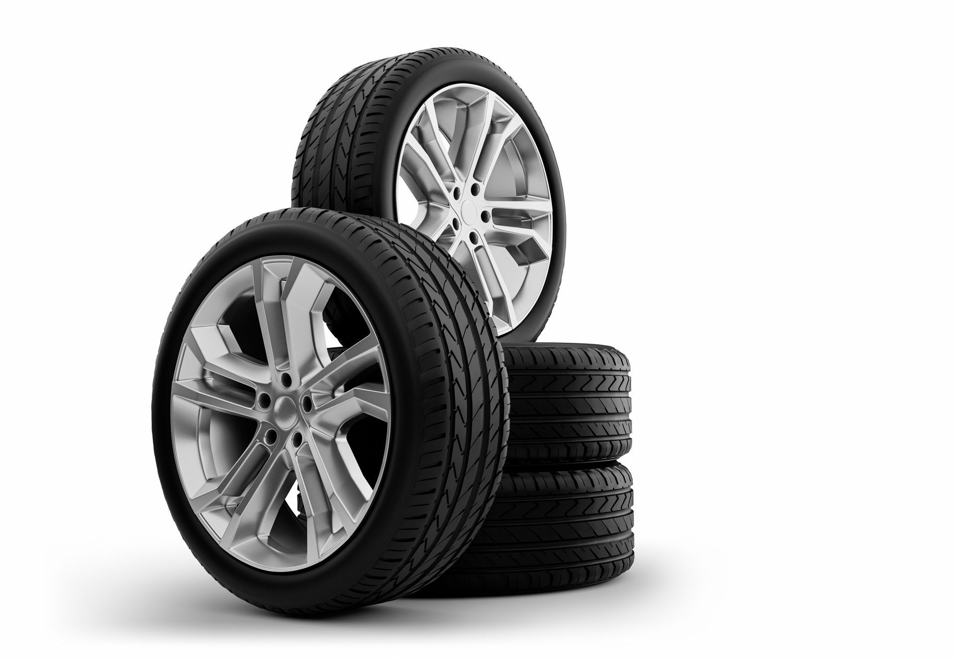 Four car tires stacked against a white background.