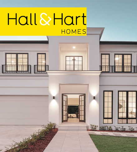 A white house with a yellow sign that says hall & hart homes