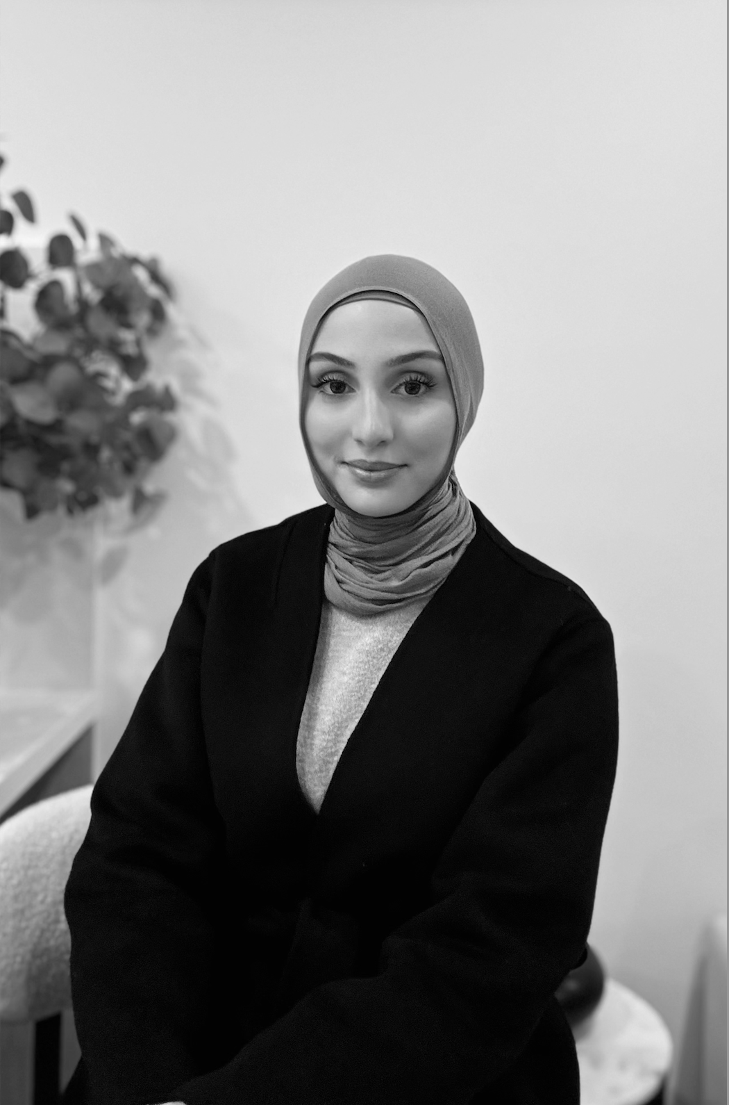 A black and white photo of a woman standing on top of a hill.