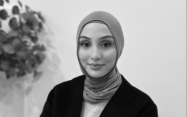 A black and white photo of a woman wearing sunglasses and a jacket.