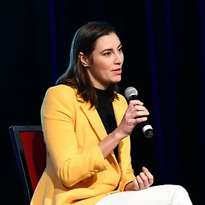 A woman is holding a microphone in a black and white photo.