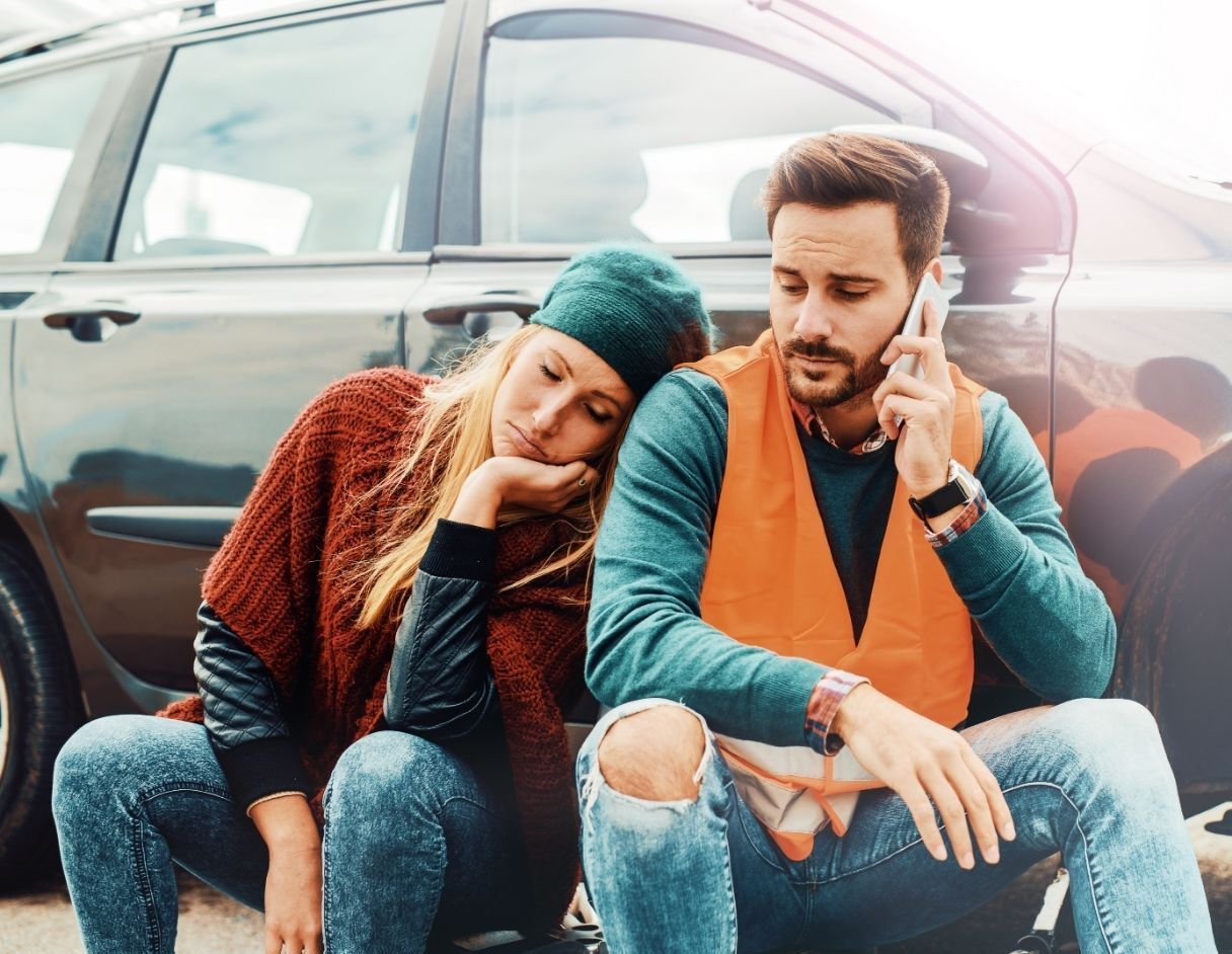 man and woman sitting outside locked car