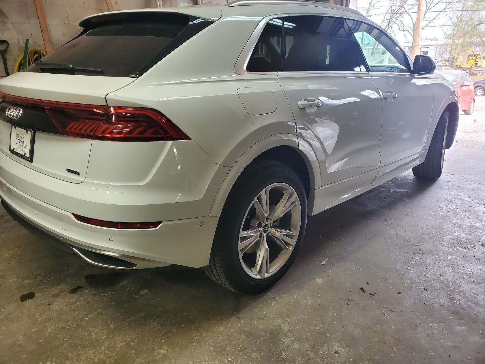 White SUV parked in a garage, rear three-quarter view with tinted windows and alloy wheels