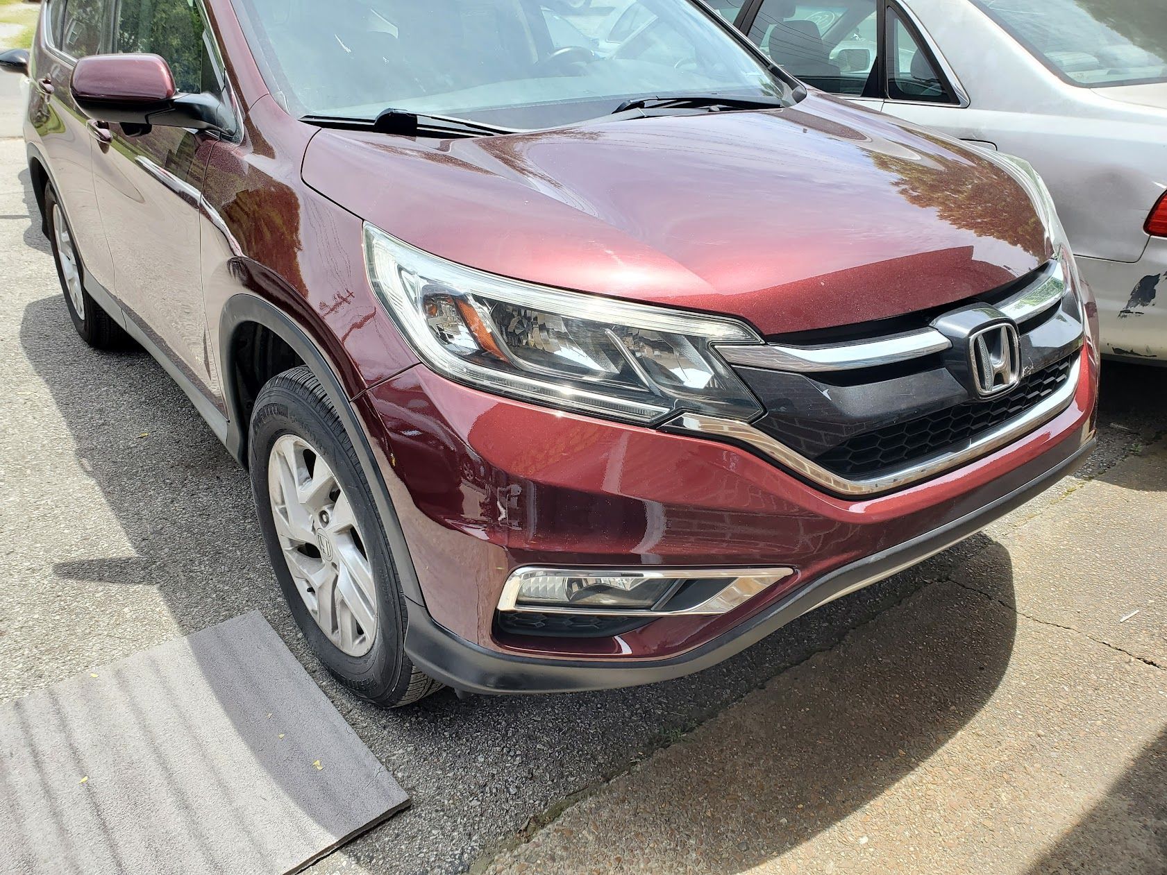 Maroon Honda SUV parked in a lot beside a silver car, front view