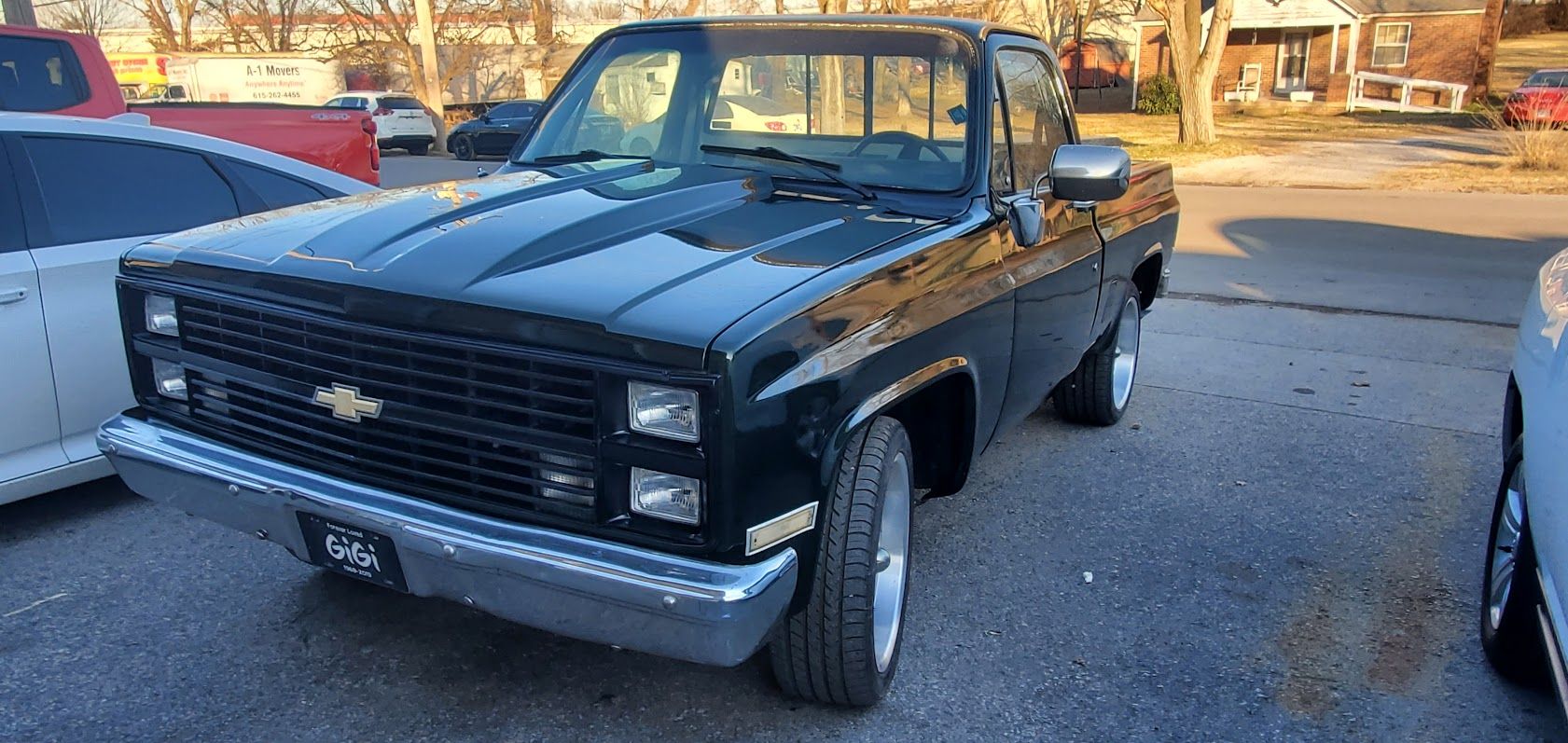 Black pickup truck parked outdoors in a lot, front view with chrome bumper and grille