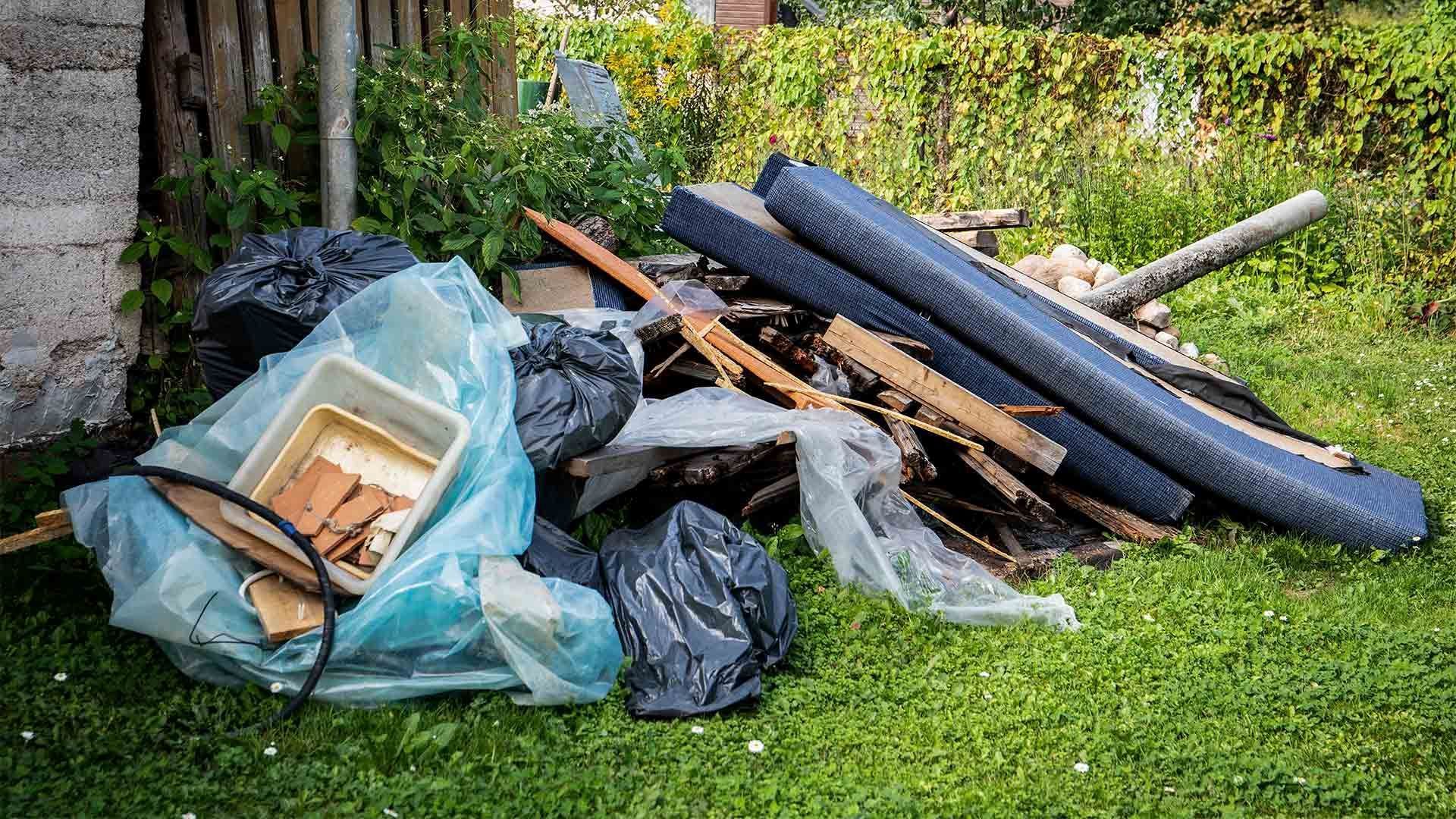 A pile of trash is sitting on top of a lush green lawn.