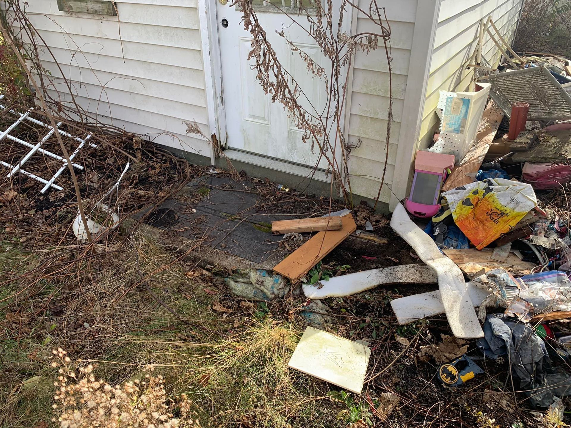 A pile of trash is sitting in front of a house.