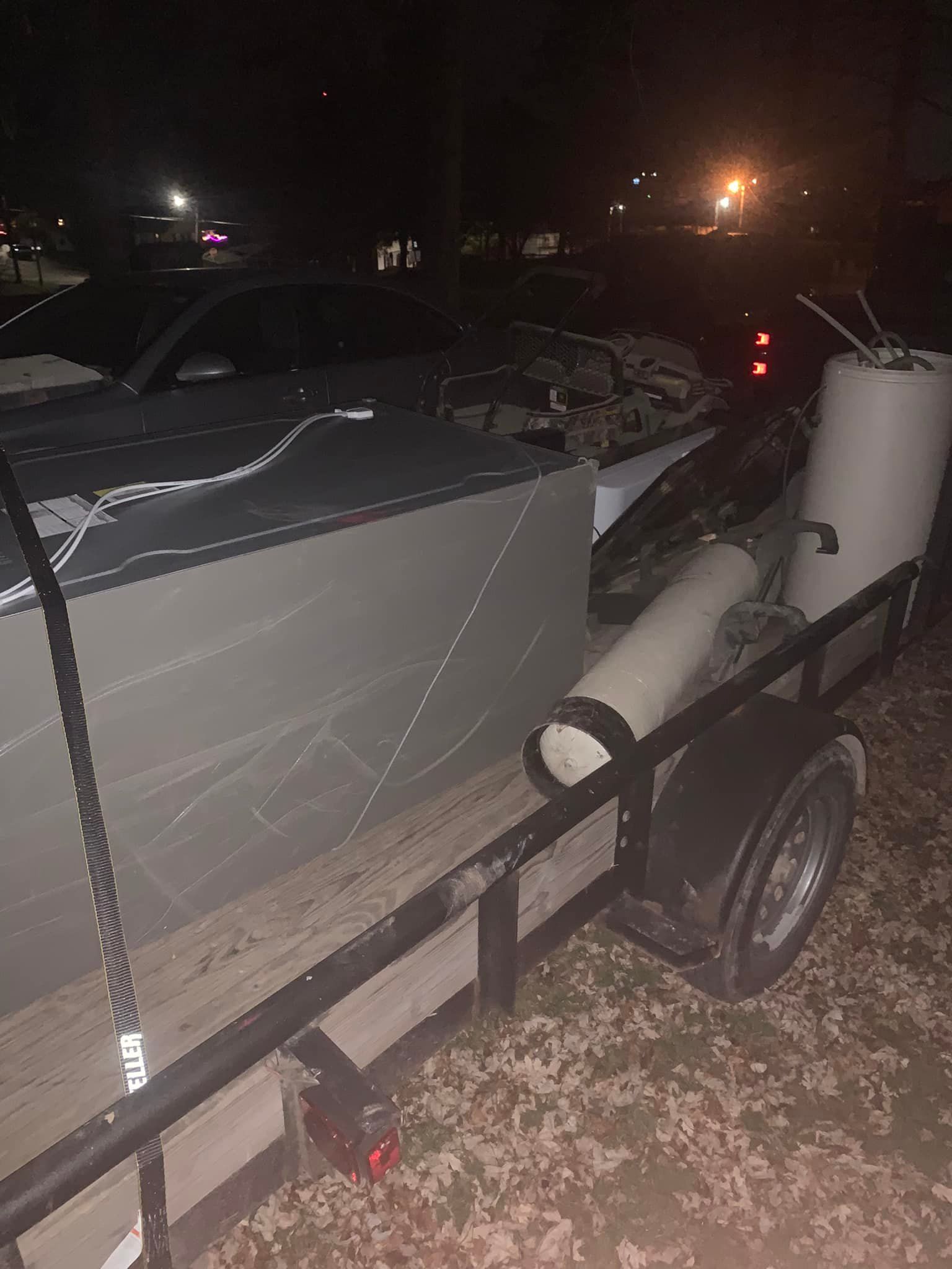 A boat is sitting on top of a trailer at night.