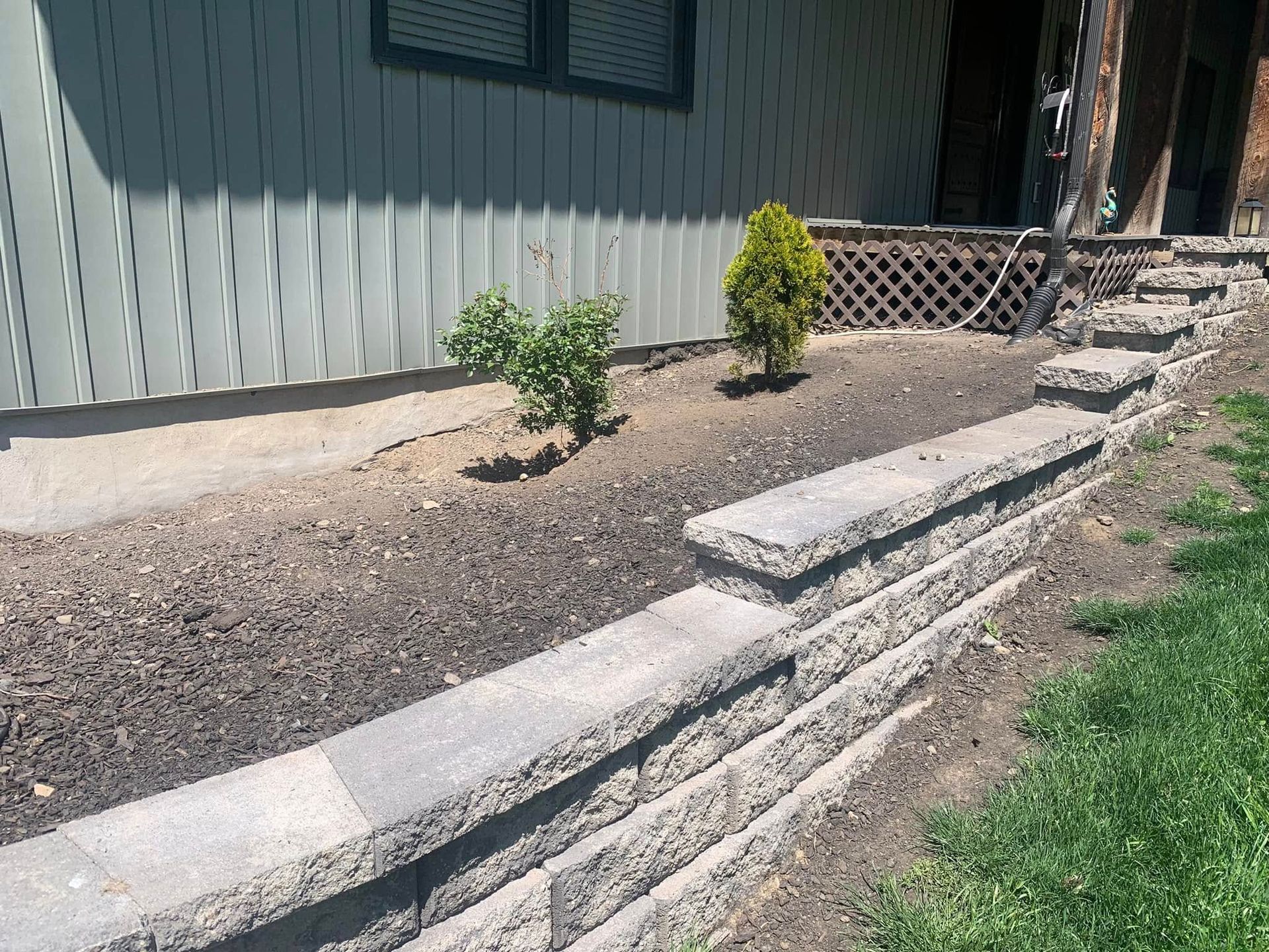 There is a stone wall in front of a house.