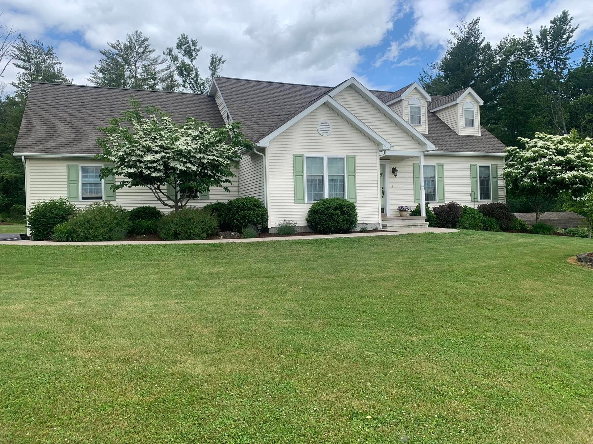 A white house with a large lawn in front of it