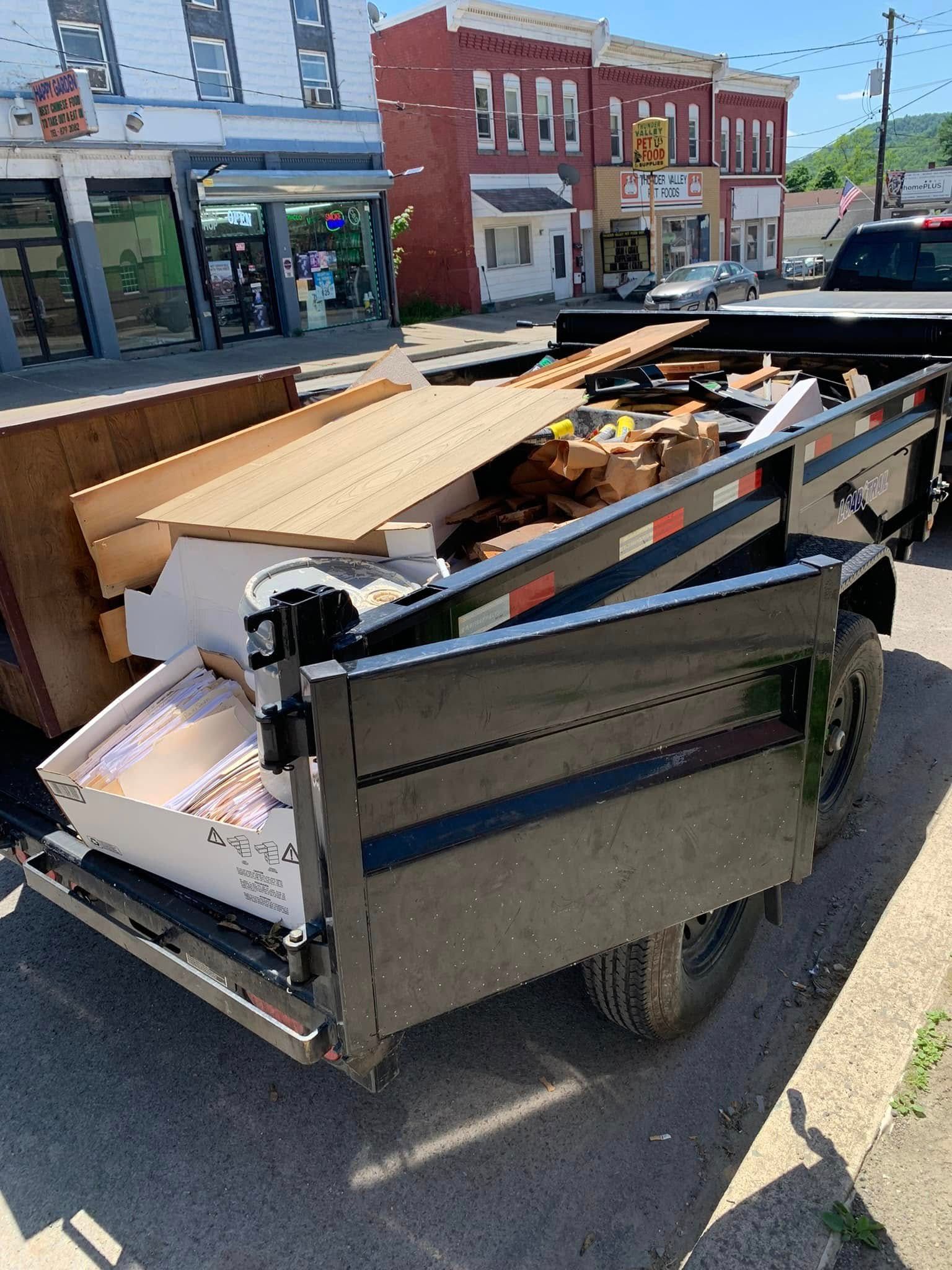 A trailer filled with boxes is parked on the side of the road.