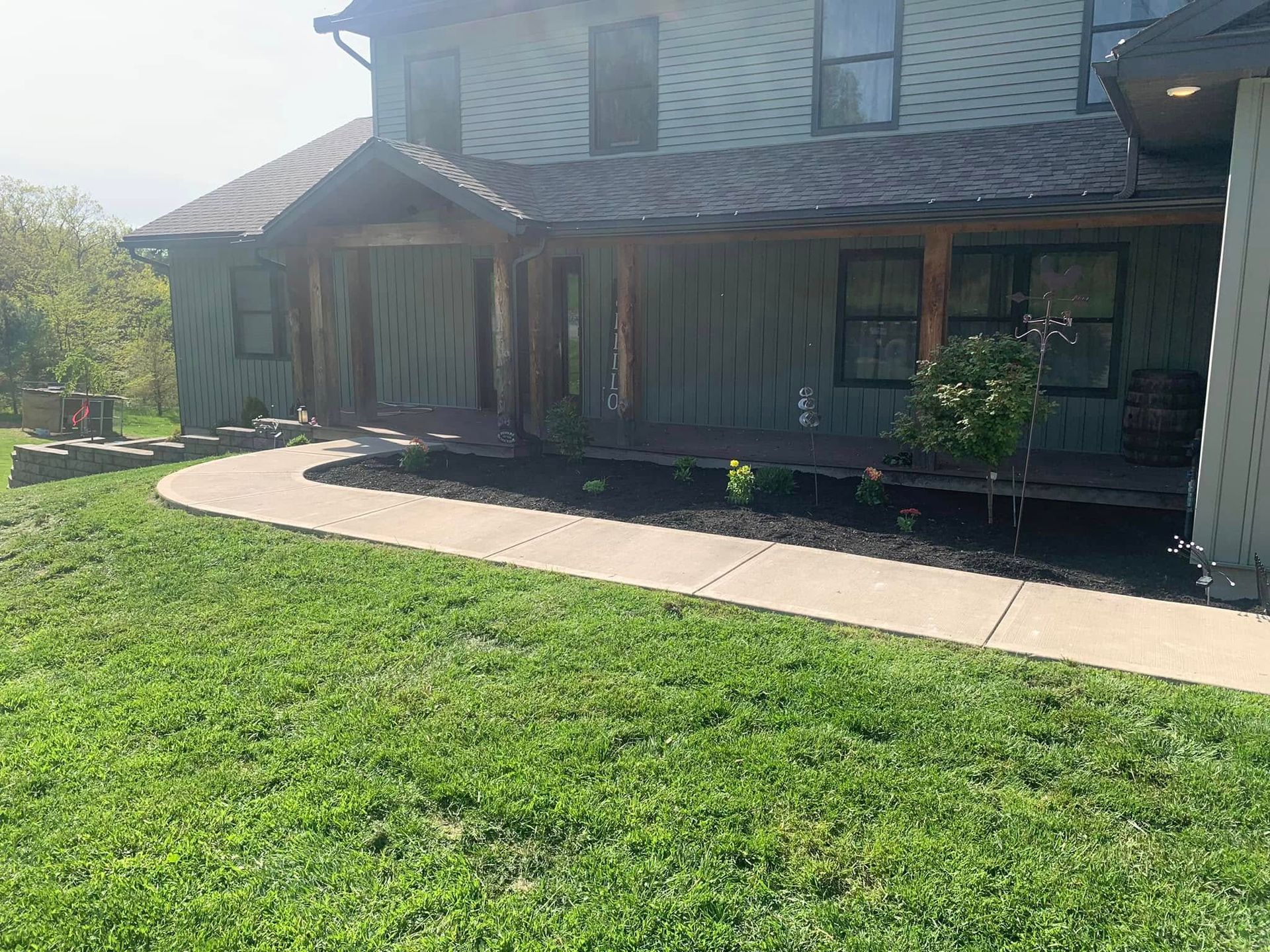 A large house with a lush green lawn and a walkway leading to it.